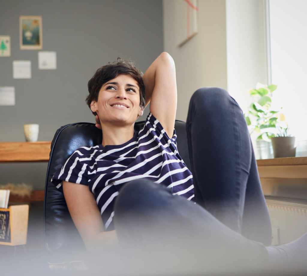 a woman relaxing, smiling in a chair after getting dental sedation for being a nervous patient